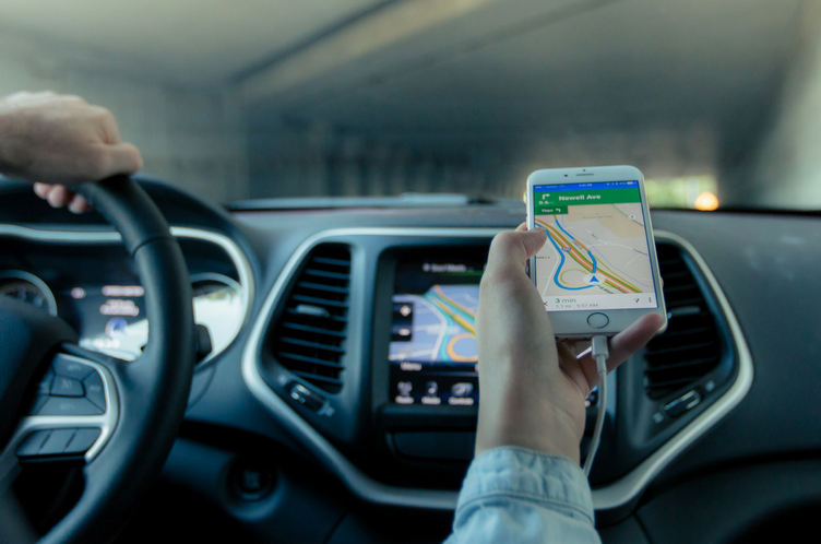 An Uber driver looks at a map on their phone.