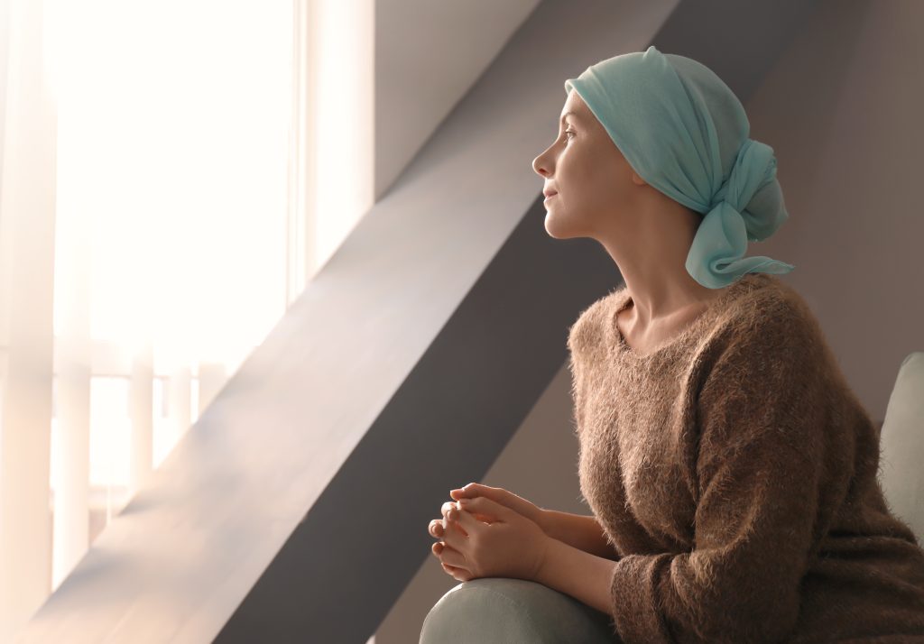 A cancer patient stares out a window
