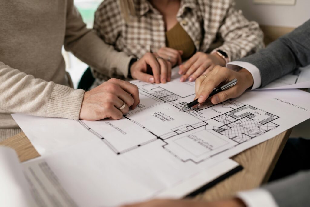 A couple looks over the blueprints of their renovation with a contractor.